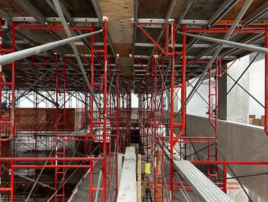 Interior scaffolding installed at the Sick Inc campus for construction access in a large atrium. 