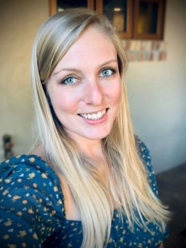 Smiling woman with long blonde hair and blue eyes.