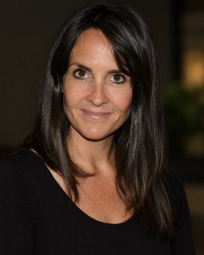 Smiling woman with long dark hair in a black top.