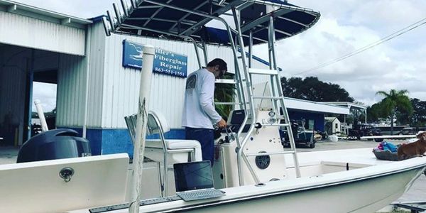 marine surveyor testing the gps on a white fiberglass center console boat with a hard top