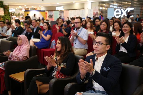 Audience clapping at an event in a conference hall.