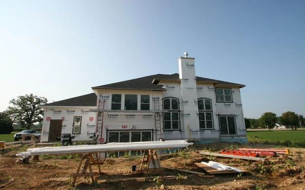 two-story home with backyard and blue sky