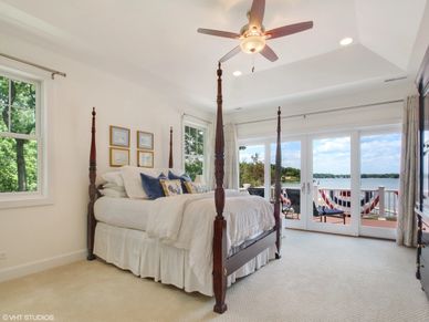 four-poster bed with white blanket in bedroom with transoms