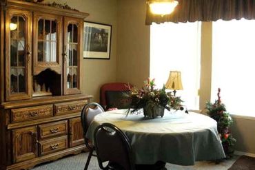 Traditional dining room with wooden china cabinet and round table.