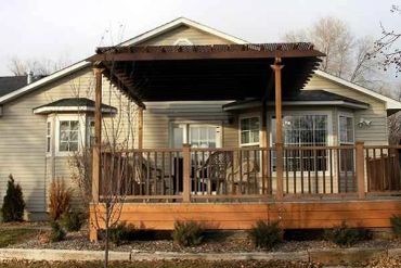 Wooden deck with pergola attached to a house.