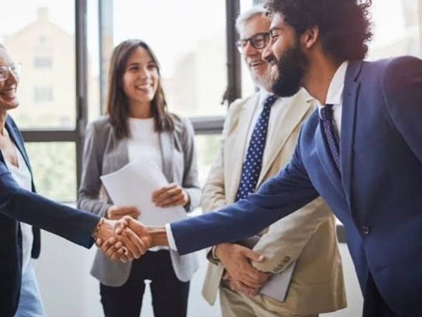 Dos personas estrechándose la mano en un ambiente laboral.