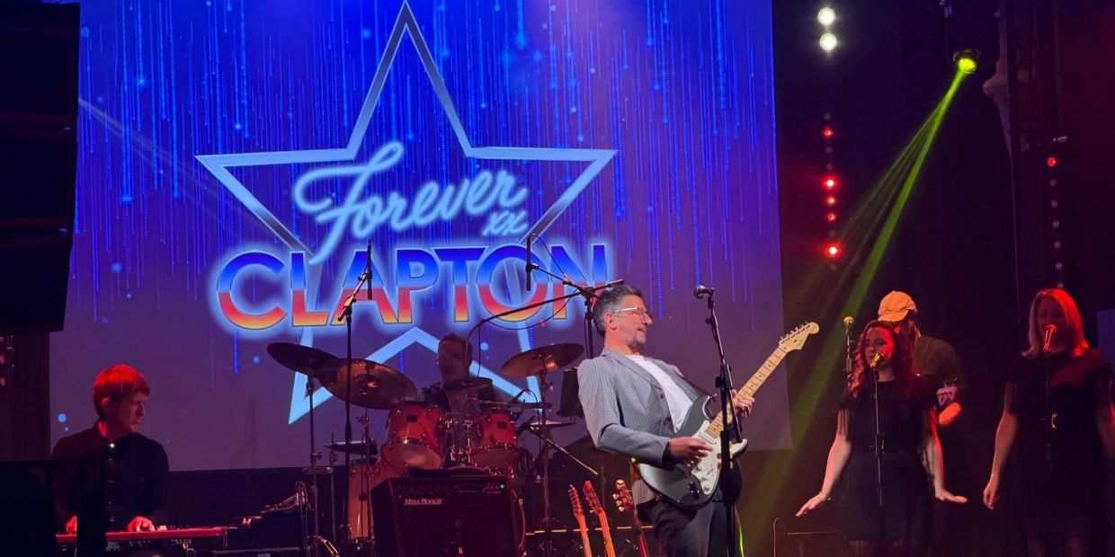 Band performing live with 'Forever in Clapton' projected on the screen.