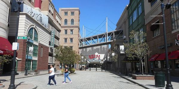 Urban street scene with pedestrians and theater marquee under a clear blue sky.