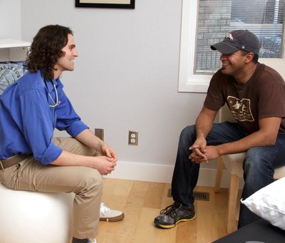 Dr. Leins sitting and talking with a patient.