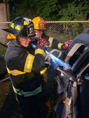 Firefighters using hydraulic tools to rescue in a vehicle accident.