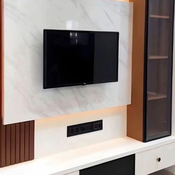 Modern living room TV setup with marble panel and wooden accents.