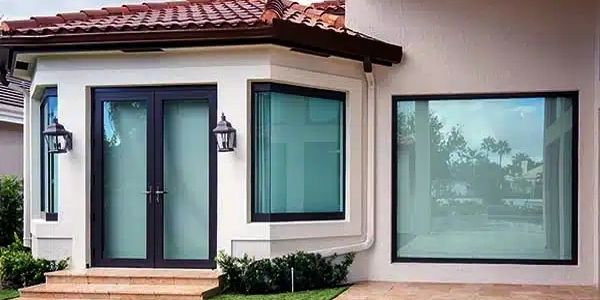 Hurricane impact windows and doors installed on a Southwest Florida home with modern coastal design and tile roofing.