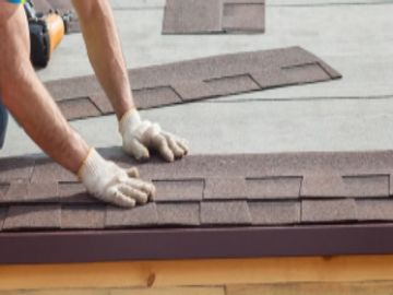 Roofing contractor installing shingles for roof services by ICAS Storm Restoration FL