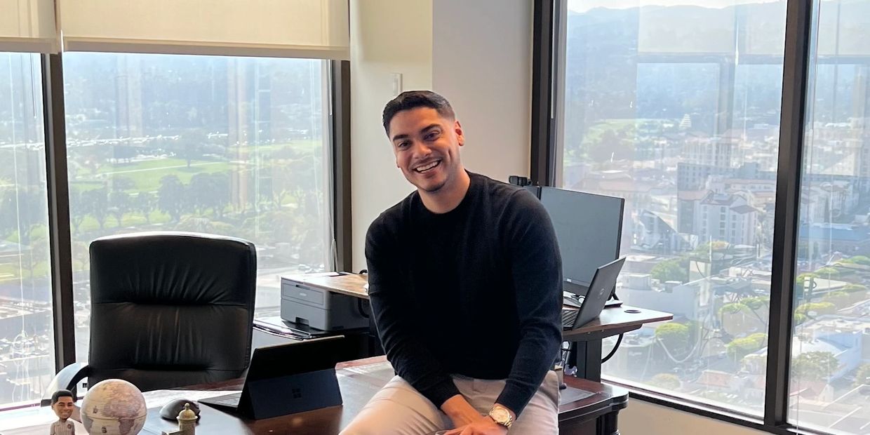 A profile picture of team member Fernando in a modern office with windows overlooking the city.