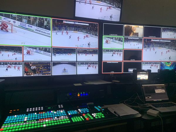Broadcast control room showing multiple hockey game feeds on screens.