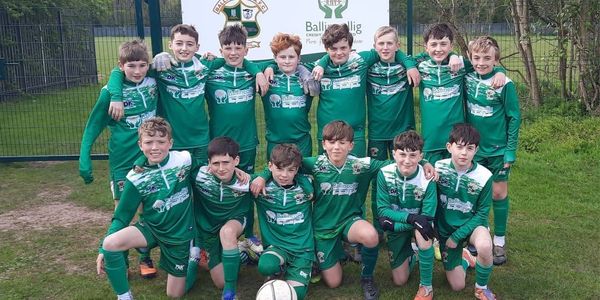 Youth soccer team posing for a photo in green uniforms.