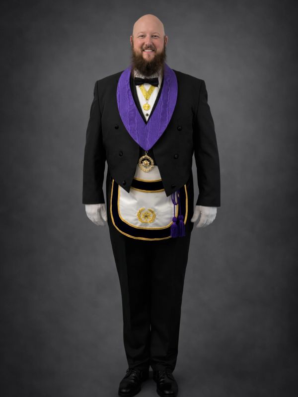 Man in formal Masonic regalia with purple collar and white gloves.