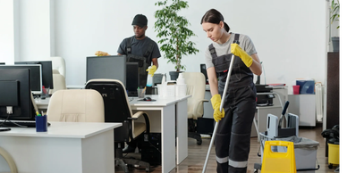 Two people cleaning an office.