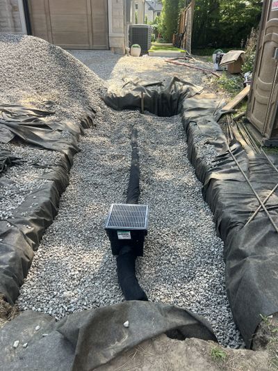 Swale directing runoff to catch basin, connected to infiltration bed for subsurface stormwater manag