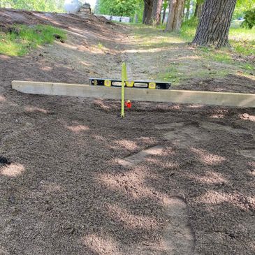 A level tool placed on gravel for ground leveling.