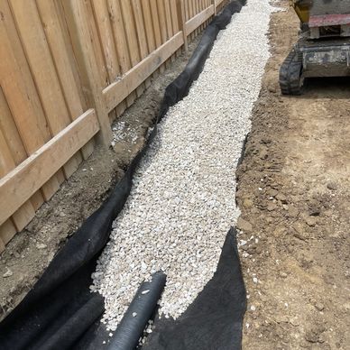 Subsurface drainage system installed to capture and redirect rear yard water.