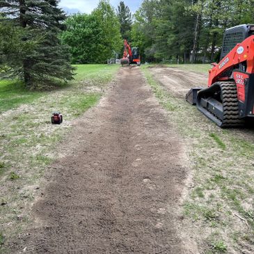 Excavation work in progress on a dirt path with machinery.