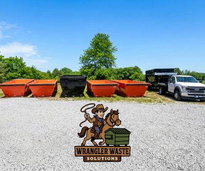 Multiple waste dumpsters and a truck under a clear blue sky at Wrangler Waste Solutions.
