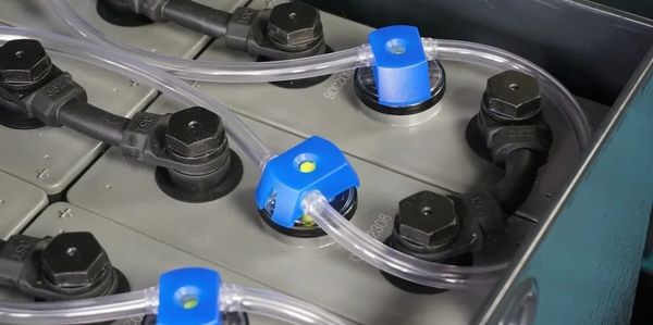 Close-up of a battery with connected cables and tubes.