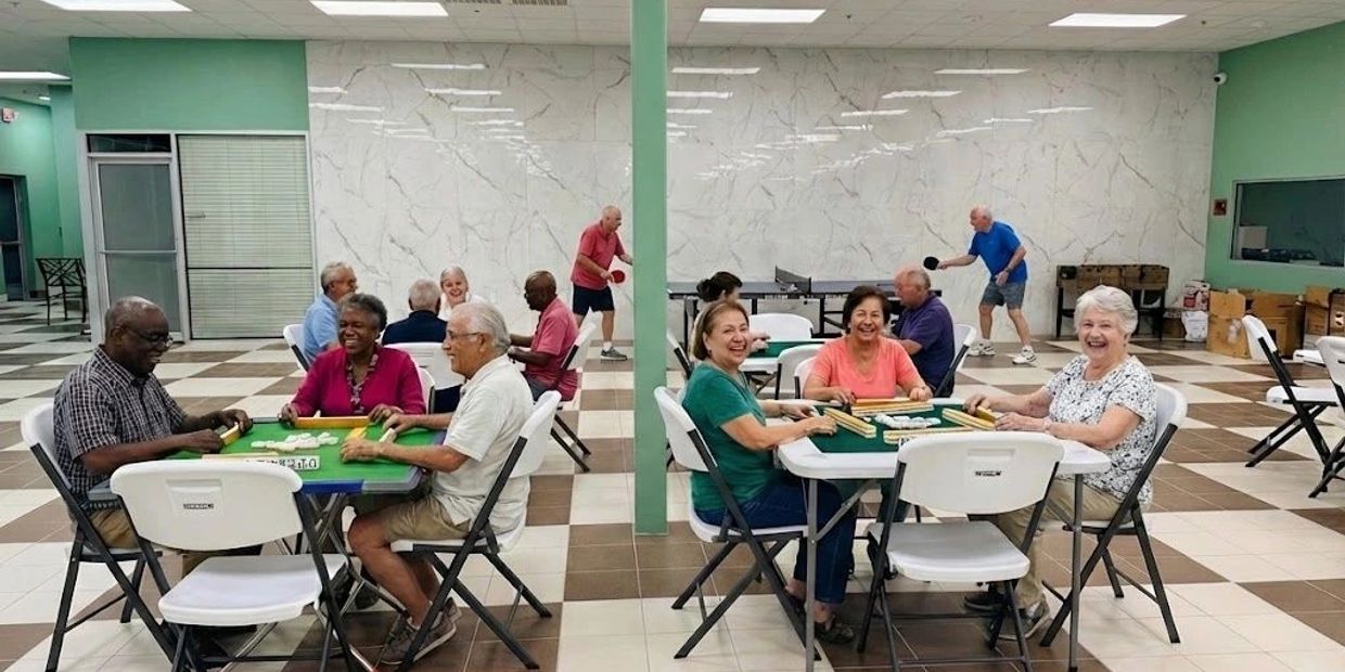 Seniors enjoying games like mahjong and table tennis in a community center.