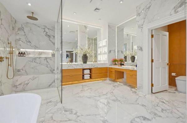 Luxurious marble bathroom with wooden cabinets.