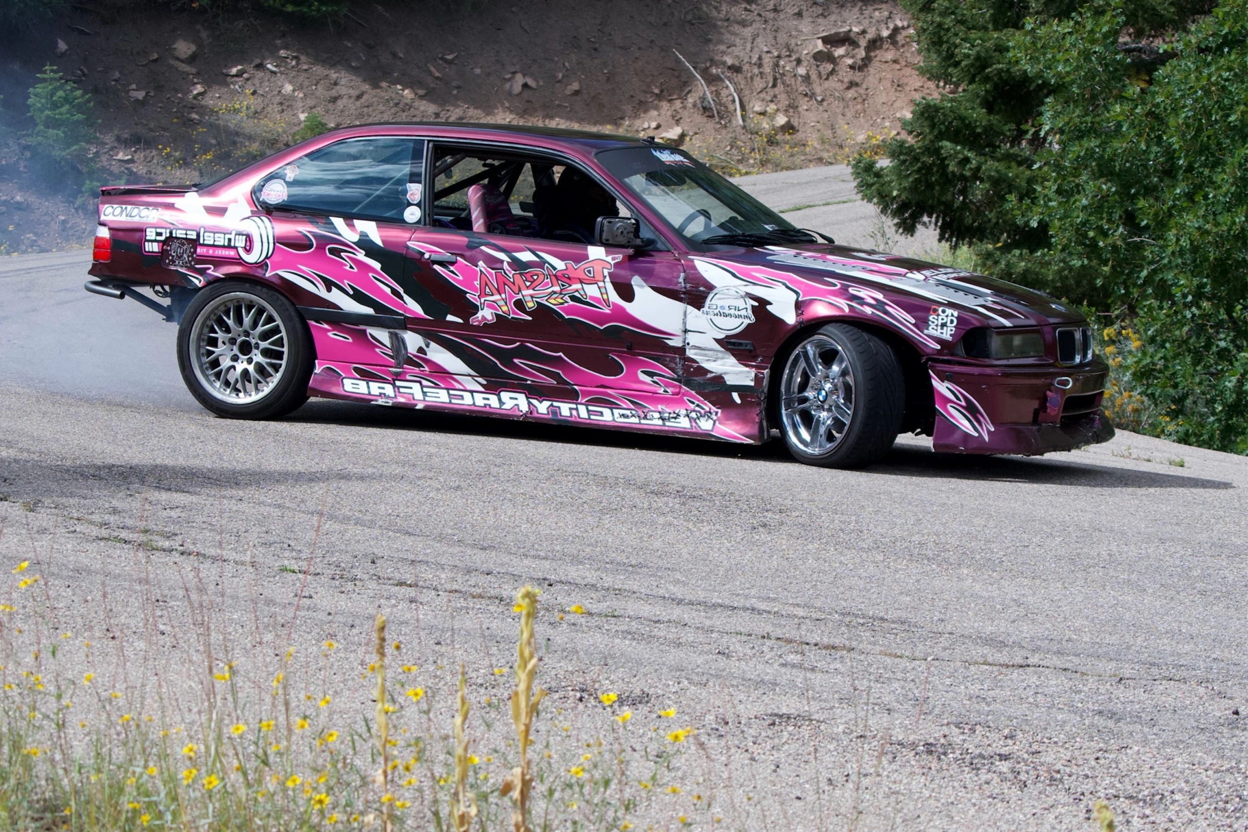 Colorful drift car with vivid decals on a mountain road.