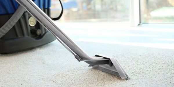 Carpet cleaning machine deep cleans a white carpet.