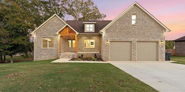 Modern brick house with a two-car garage at sunset.