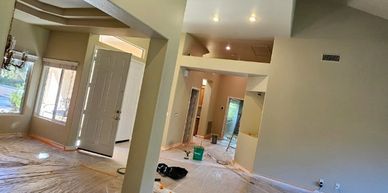 Interior of a house undergoing renovation with plastic coverings on the floor.