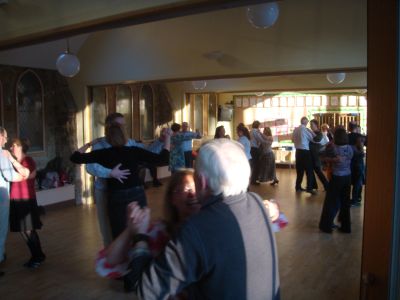People dancing in a sunlit room.