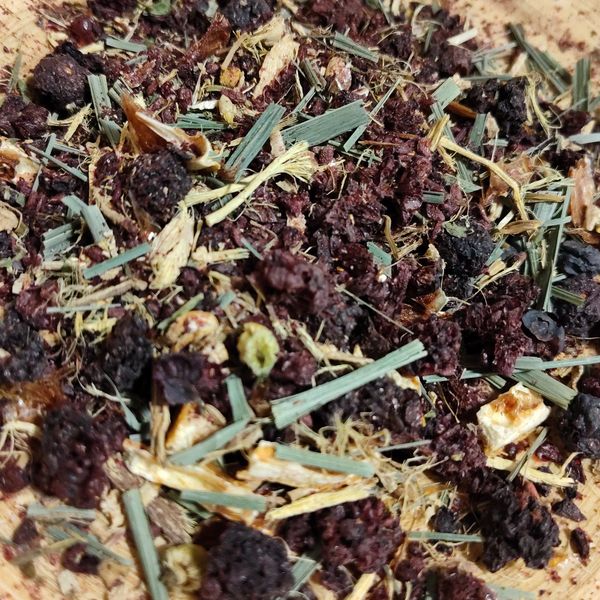 A close-up of dried herbal tea blend with berries and leaves.
