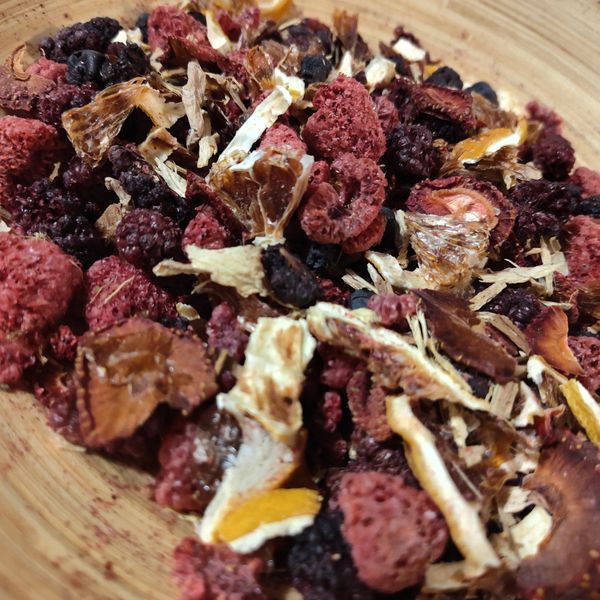 Close-up of assorted dried berries and fruit pieces on a wooden surface.