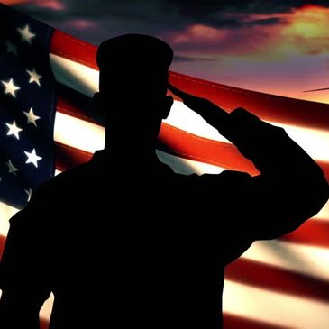 silhouette of a soldier saluting a USA flag in the background  