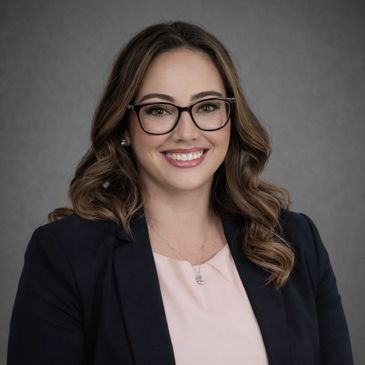 Smiling woman with glasses in professional attire.