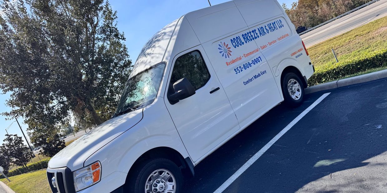 White service van parked in a lot with clear company branding on the side.