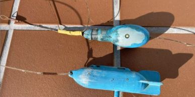 Two blue underwater devices on a tiled surface.