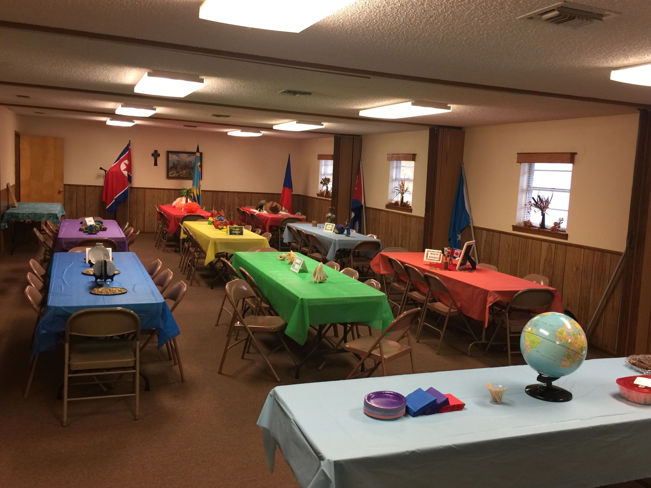 Colorful decorated room with flags and tables.