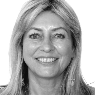 Smiling woman with blonde hair in a black and white photo.