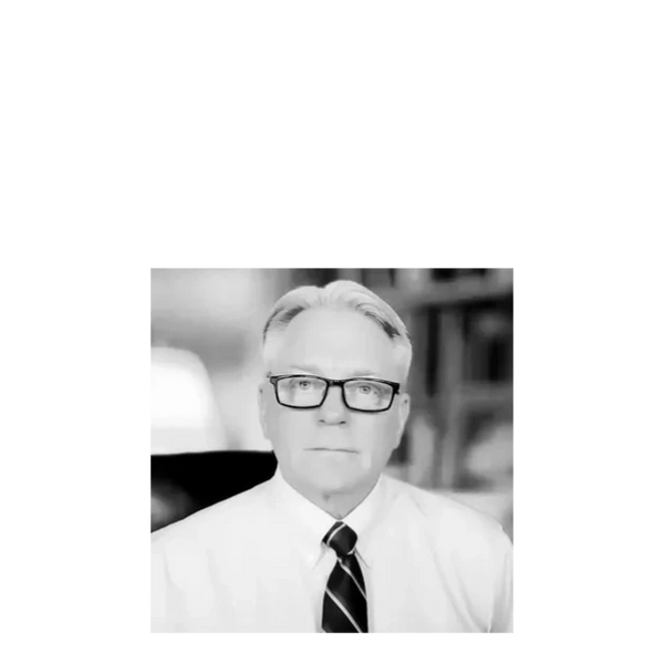 Portrait of a distinguished man wearing glasses, a white shirt, and a striped tie.