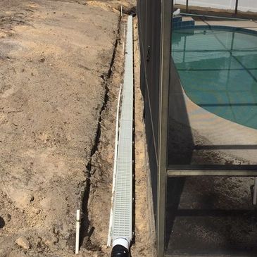 drain system being installed in a yard next to a pool