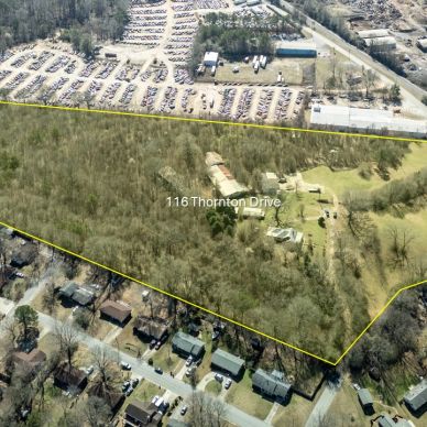 Aerial view of 116 Thornton Drive property outlined in yellow with wooded and cleared areas.
