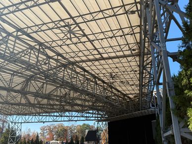 Spacious outdoor amphitheater with a large roof and empty seating under clear skies.