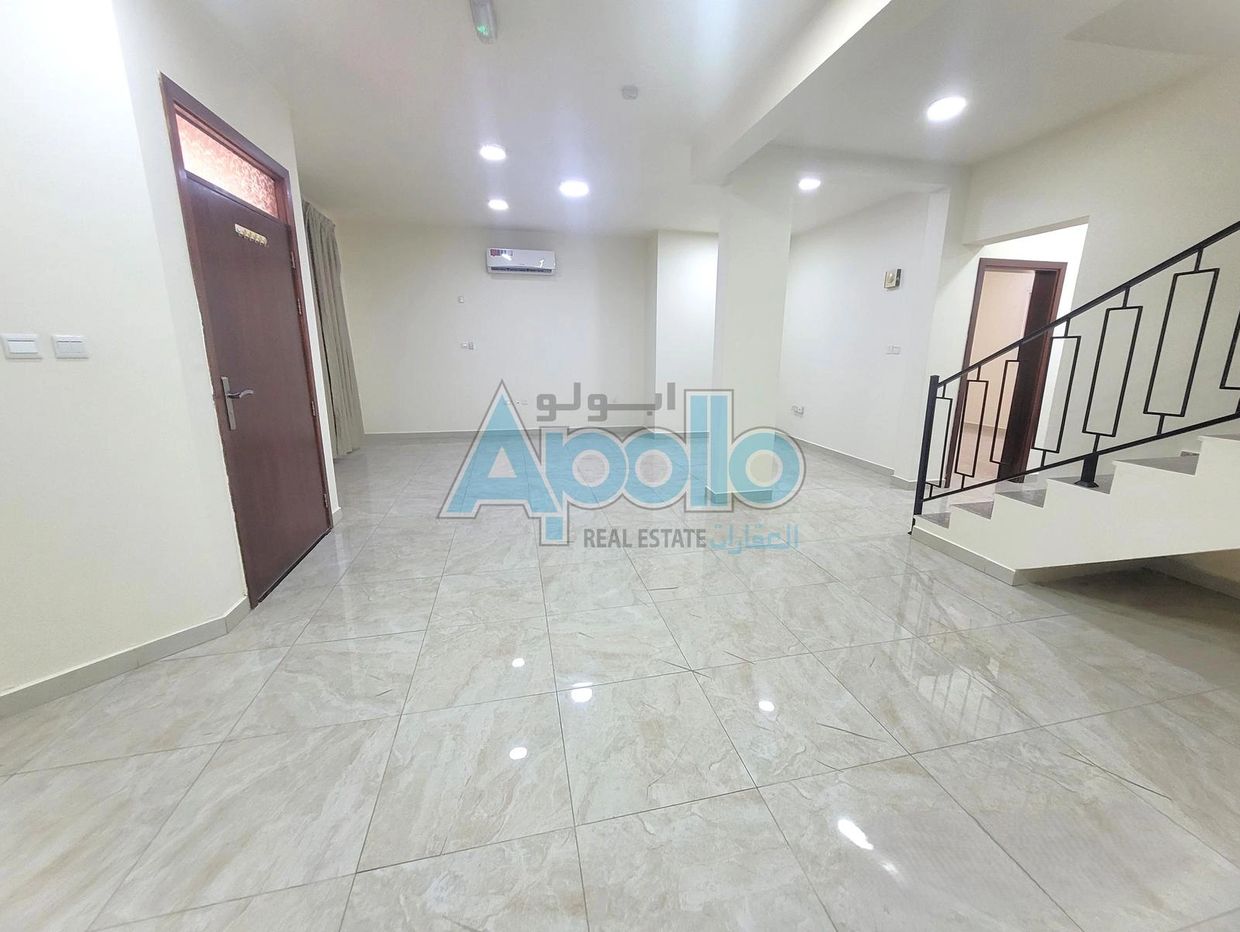 Empty modern room with tiled floor, staircase, and air conditioning.