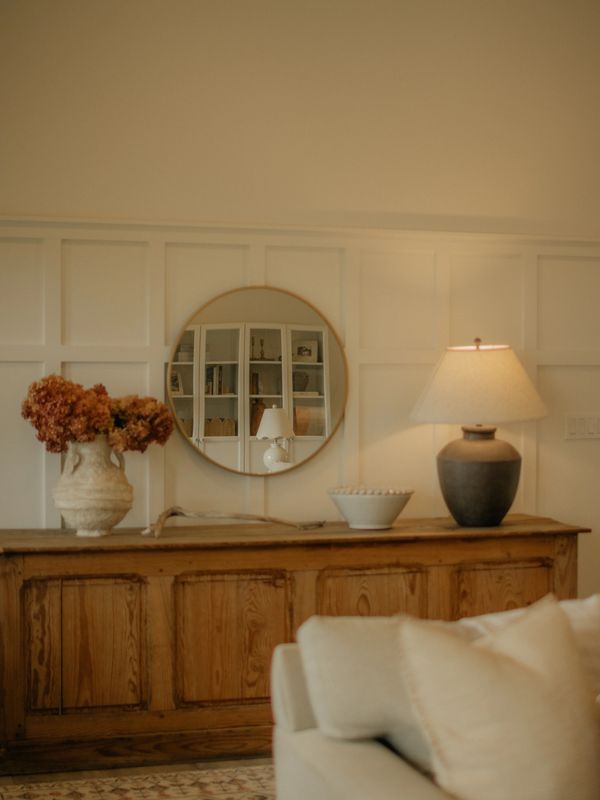 Cozy living room with neutral tones and rustic wooden cabinet.