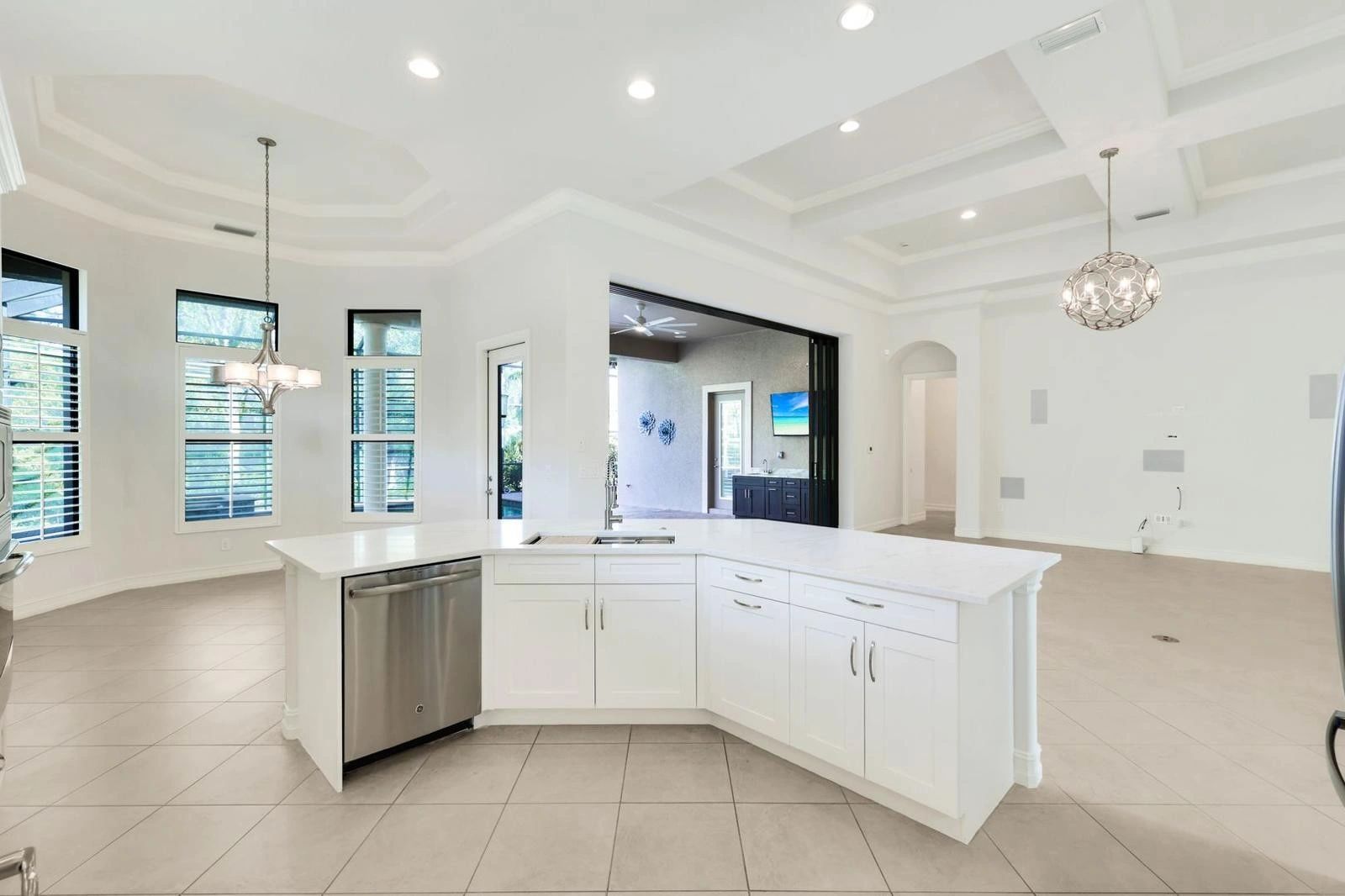 Bright modern kitchen with white cabinetry and stainless steel appliances.
